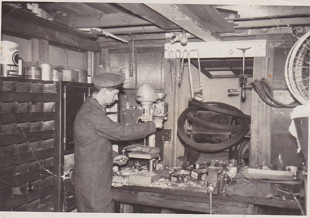 Oscar working at a drill press in his Cramerton bicycle repair shop