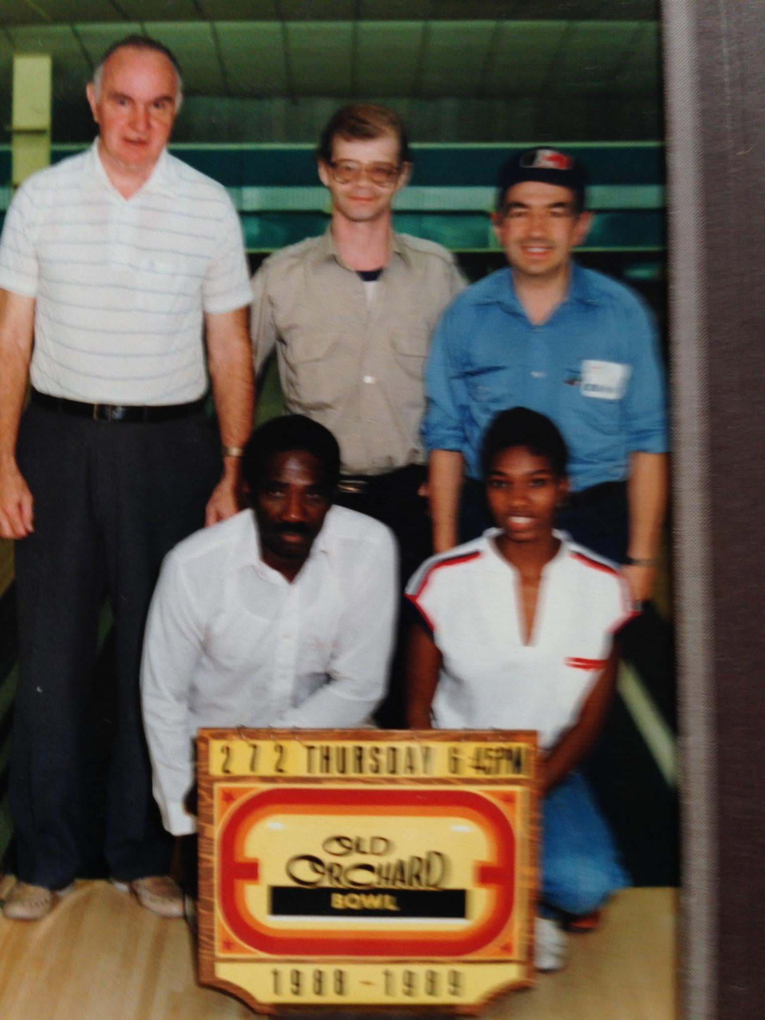 Dave Savoie in a blue shirt with his bowling team and trophy