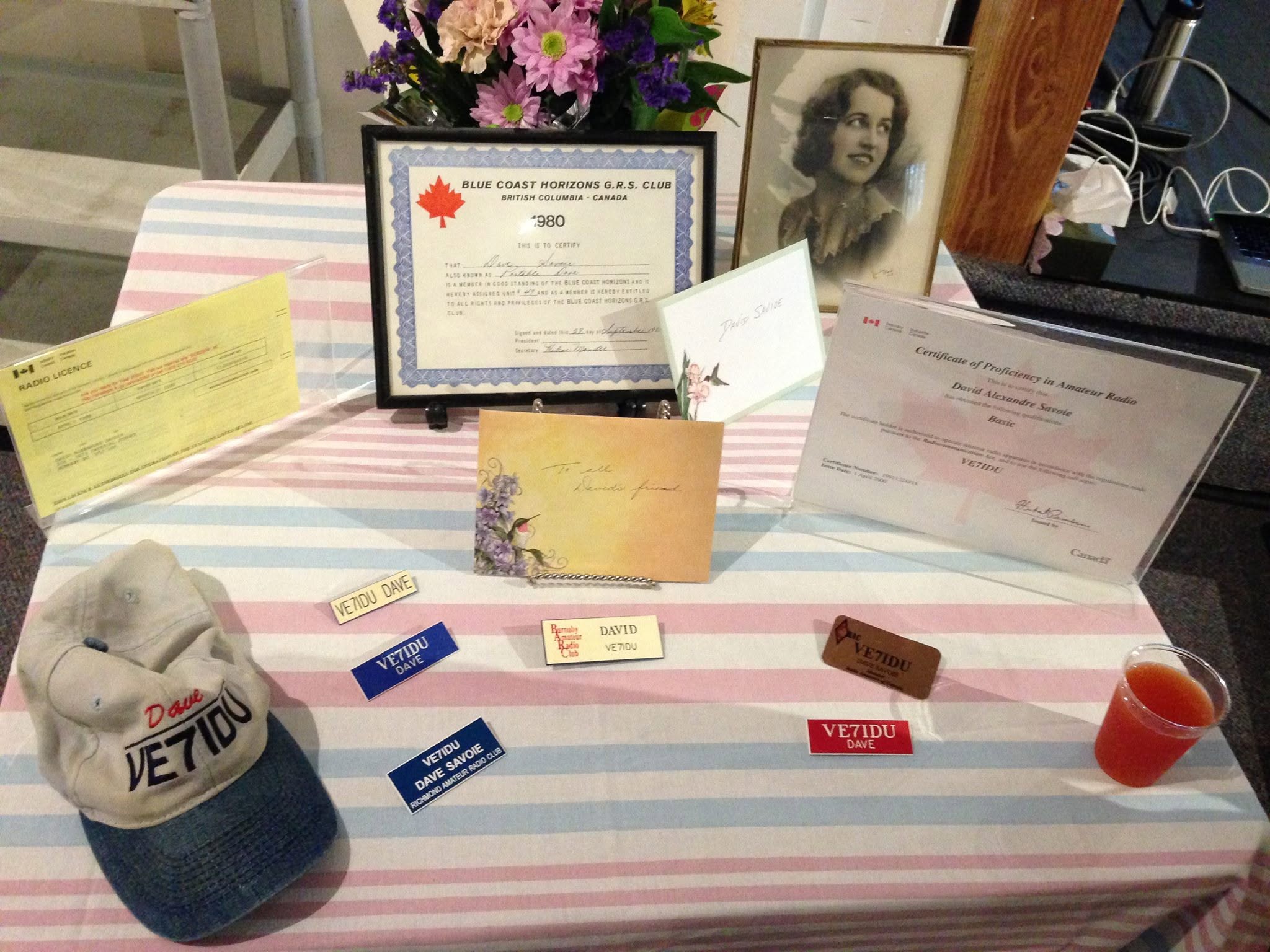 Memorial display of David Savoie's amateur radio certificate and VE7IDU items